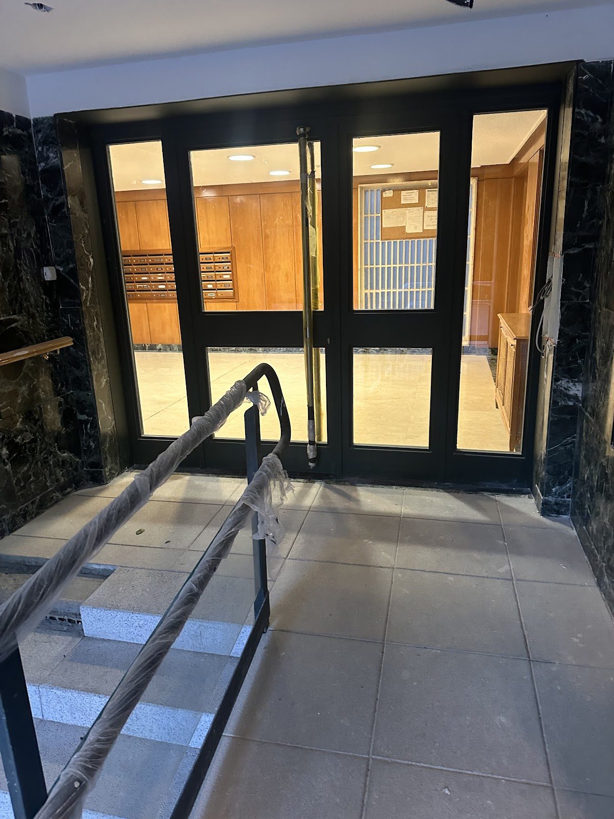 Puerta de portal y barandilla de acceso instaladas por Cerrajería Mencía